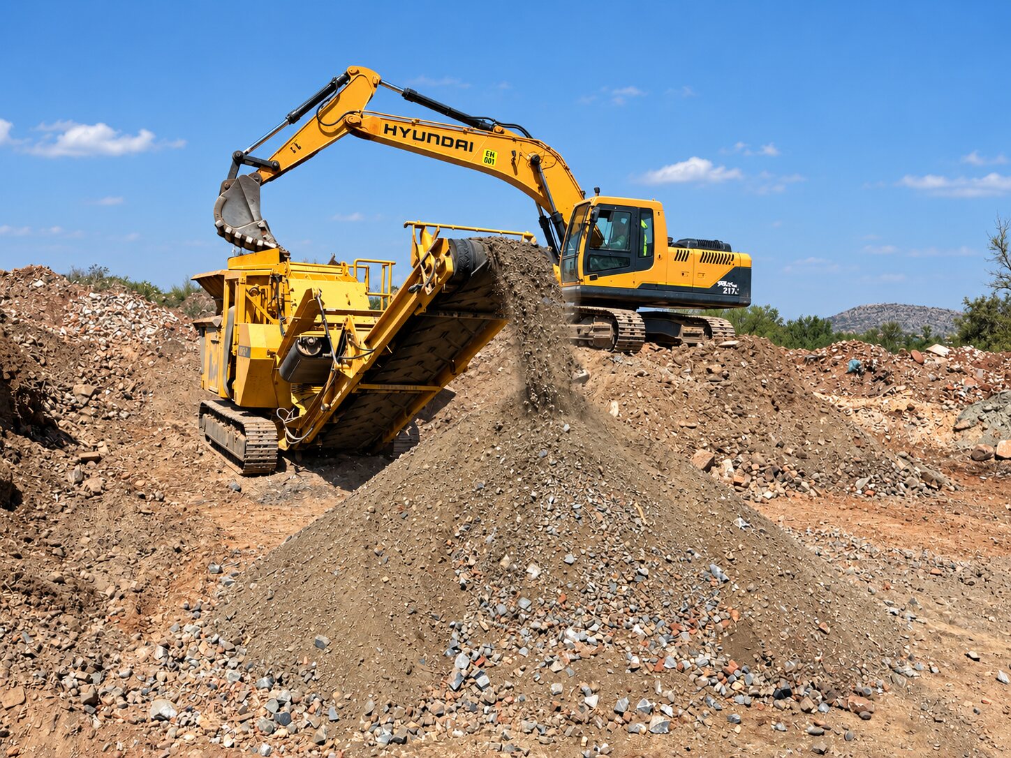 ENI Supplies excavator feeding a mobile rubble processor with recycled filling material discharging